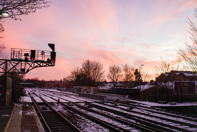 Railroad tracks against sky during sunset