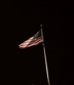 Low angle view of flag against clear sky at night