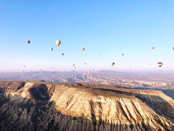 Hot air balloons flying over landscape