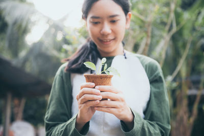 Portrait of woman holding plant