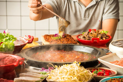 Midsection of man preparing food in kitchen