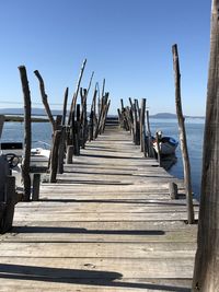 Wooden pier over sea against clear sky