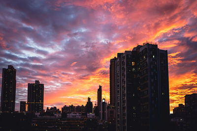 Illuminated buildings against sky during sunset