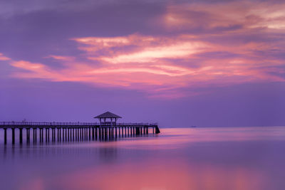 Pier over sea against sky during sunset