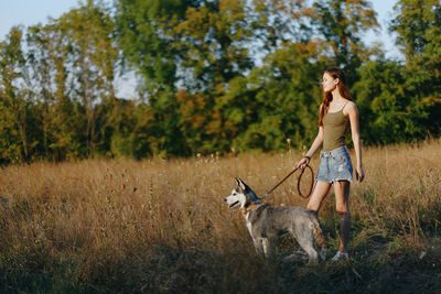 Full length of woman with dogs on field