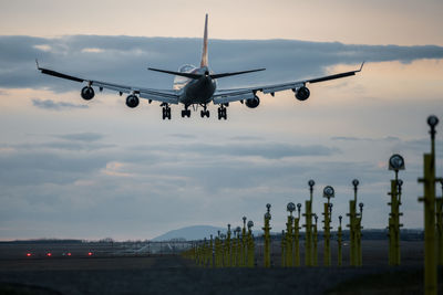 Low angle view of airplane flying against sky during sunset