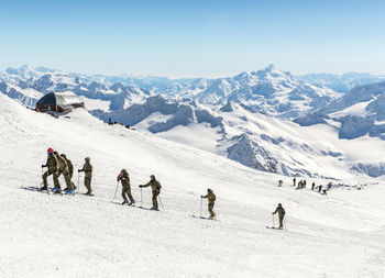 People on snow covered mountains against sky