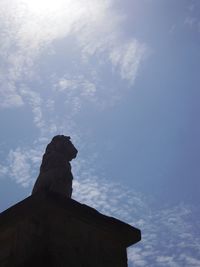 Low angle view of silhouette statue against sky