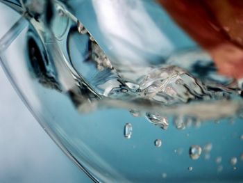 Close-up of pouring water into a glass of water