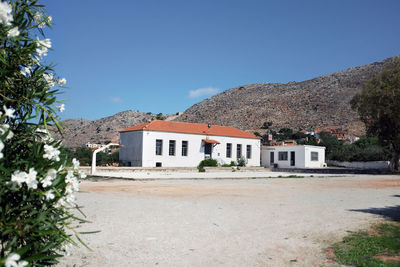 Houses and buildings against clear blue sky