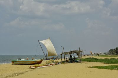 Boats moored at beach against sky