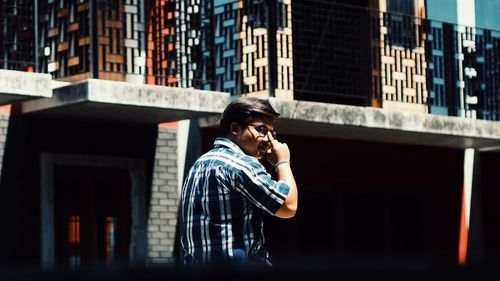 Young man using mobile phone in city