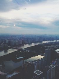 Aerial view of city against cloudy sky