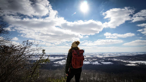 Rear view of woman standing on land against sky