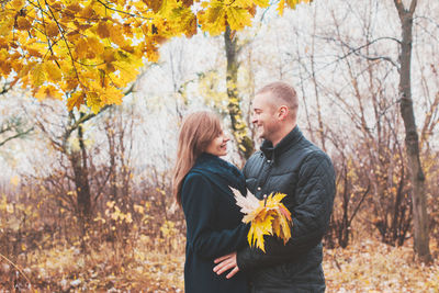 Man and woman standing by plants during autumn