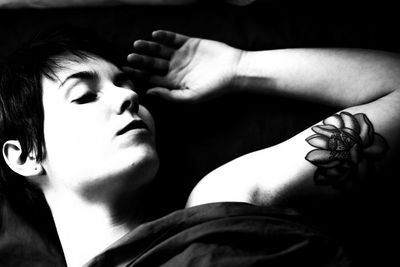 Close-up of young woman with arms raised