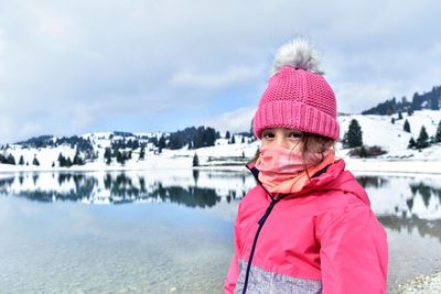 Portrait of girl wearing hat against sky during winter