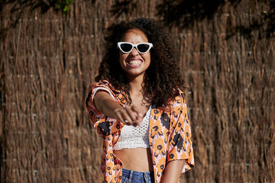 Portrait of smiling young woman wearing sunglasses