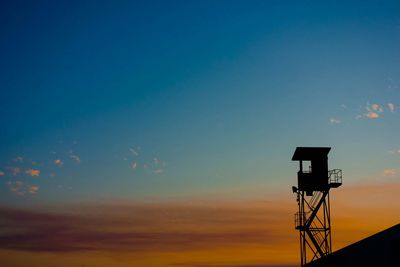 Low angle view of silhouette lookout tower against sky during sunset