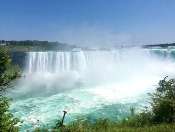 Scenic view of waterfall against sky