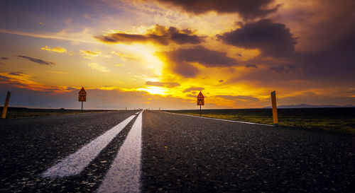 Empty road against sky during sunset