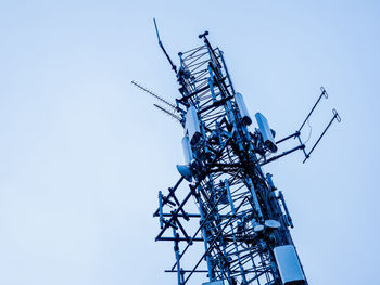 Low angle view of communications tower against clear blue sky