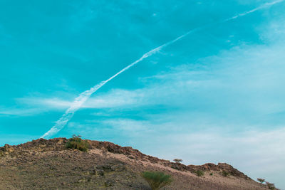 Low angle view of vapor trail against blue sky