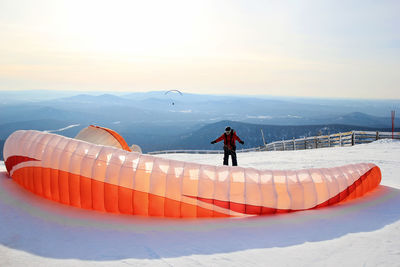 Man on snow covered mountain against sky