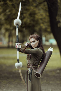 Young woman with arms raised standing outdoors