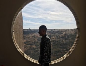 Boy looking through window