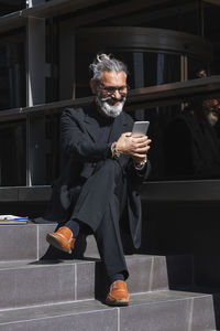 Full length of man holding mobile phone