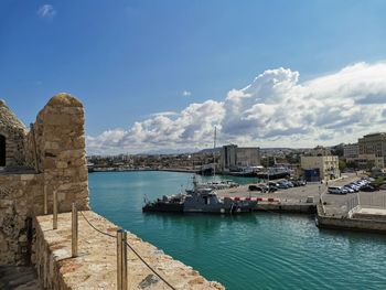 Panoramic view of bay and buildings against sky