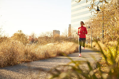 A woman on a run through the park on a warm fall day.