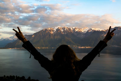 Rear view of woman looking at lake during winter