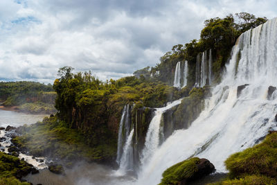 Scenic view of waterfall against sky