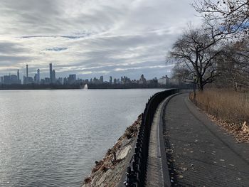 Scenic view of river by city against sky