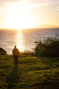 Rear view of man standing in front of sea