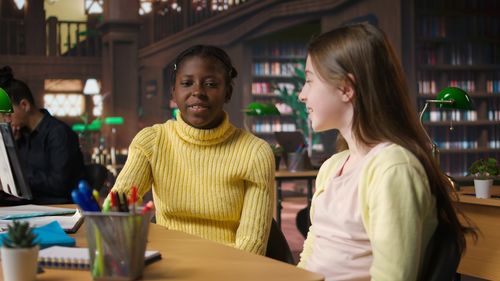 Portrait of young woman sitting on table