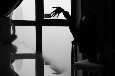 Cropped hand by window