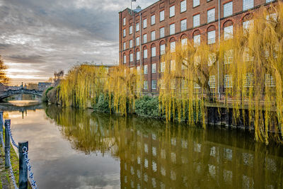 Reflection of buildings on river against sky