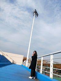 Woman standing on bridge against sky