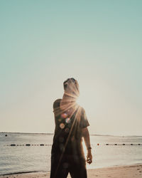 Man standing on beach against clear sky