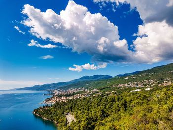 Scenic view of sea and mountains against blue sky