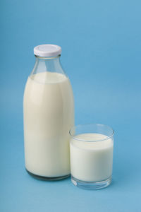 Glass of bottle against blue background