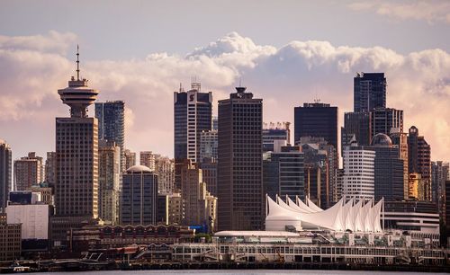 Buildings in city against cloudy sky