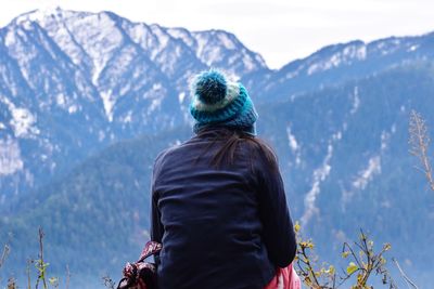 Rear view of woman looking at snowcapped mountain