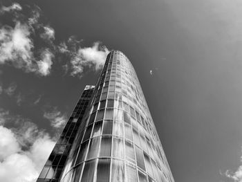 Low angle view of modern building against cloudy sky