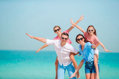 Low angle view of people at beach against sky