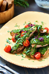 Close-up of pork ribs with garlic and herb sauce served in plate