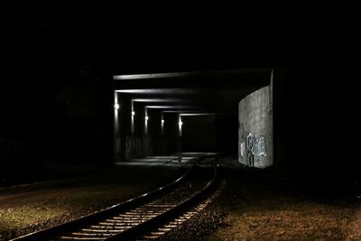 Illuminated railroad tracks in tunnel